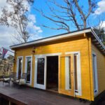 outside of yellow alpine cabin sleepout with door open