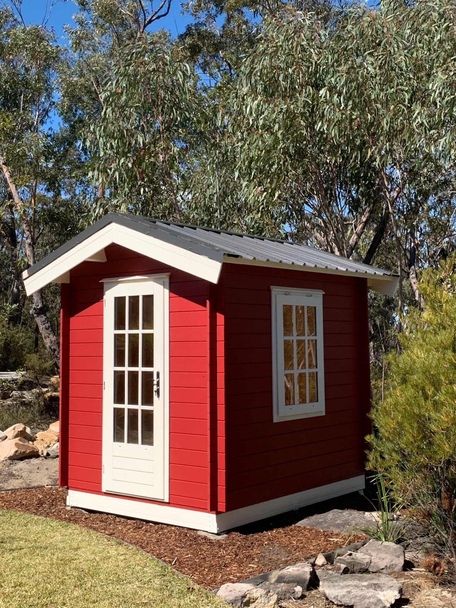 outside of painted cottage garden cabin garden shed with casement window and steel roof and steel subframe