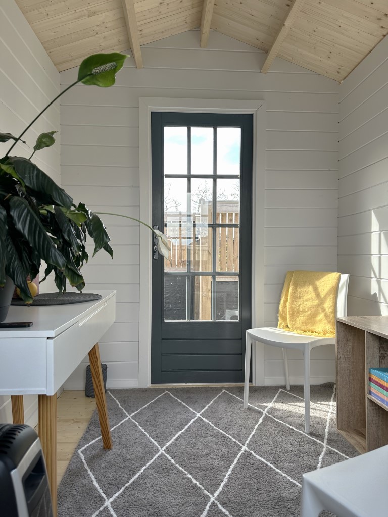 inside of painted cottage garden cabin home office with closed door