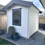 outside of painted cottage garden cabin home office with casement window