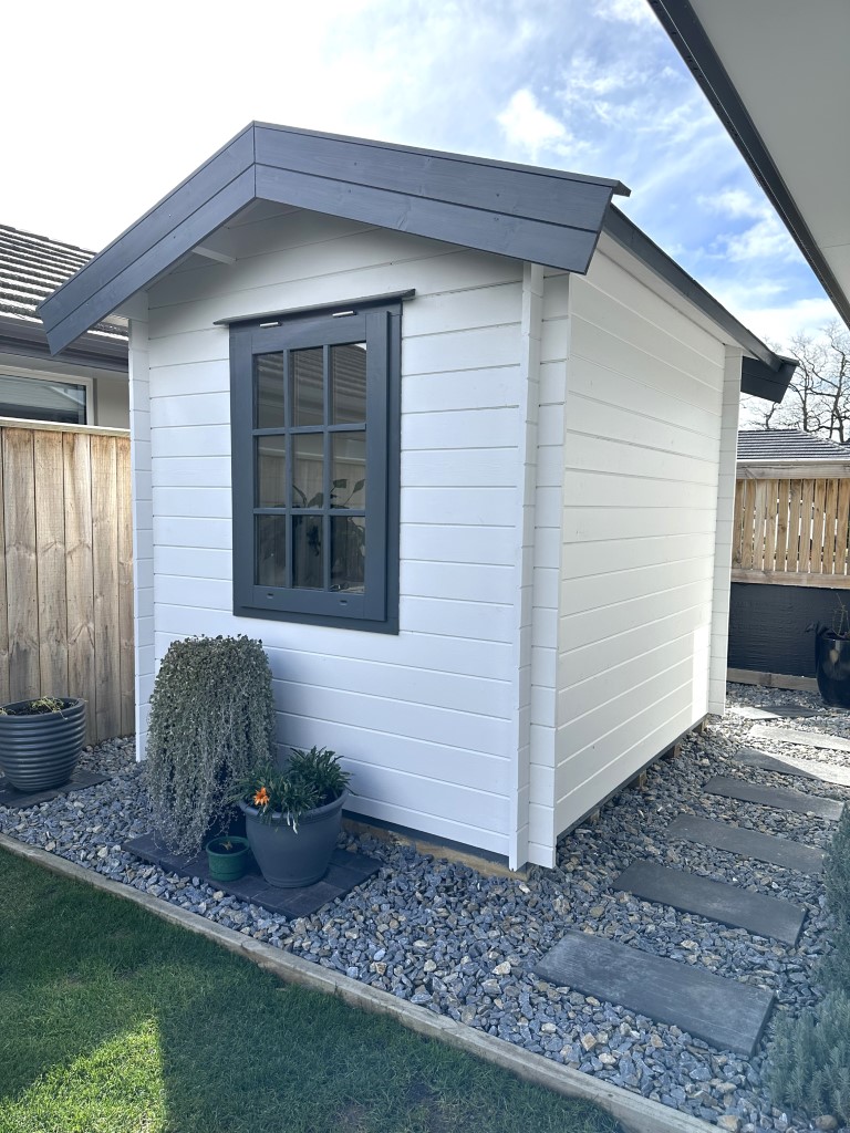 outside of painted cottage garden cabin home office with casement window