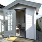 outside of painted cottage garden cabin home office with open door