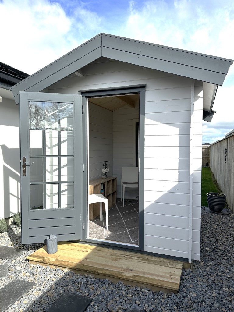 outside of painted cottage garden cabin home office with open door