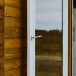 outside of lake cabin as an upholstery studio with closeup on window