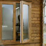 outside of lake cabin as an upholstery studio with closeup on window