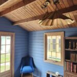 inside of painted star cabin display home office with casement window and brass light