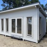 outside of painted alpine display cabin with open tilt and turn windows
