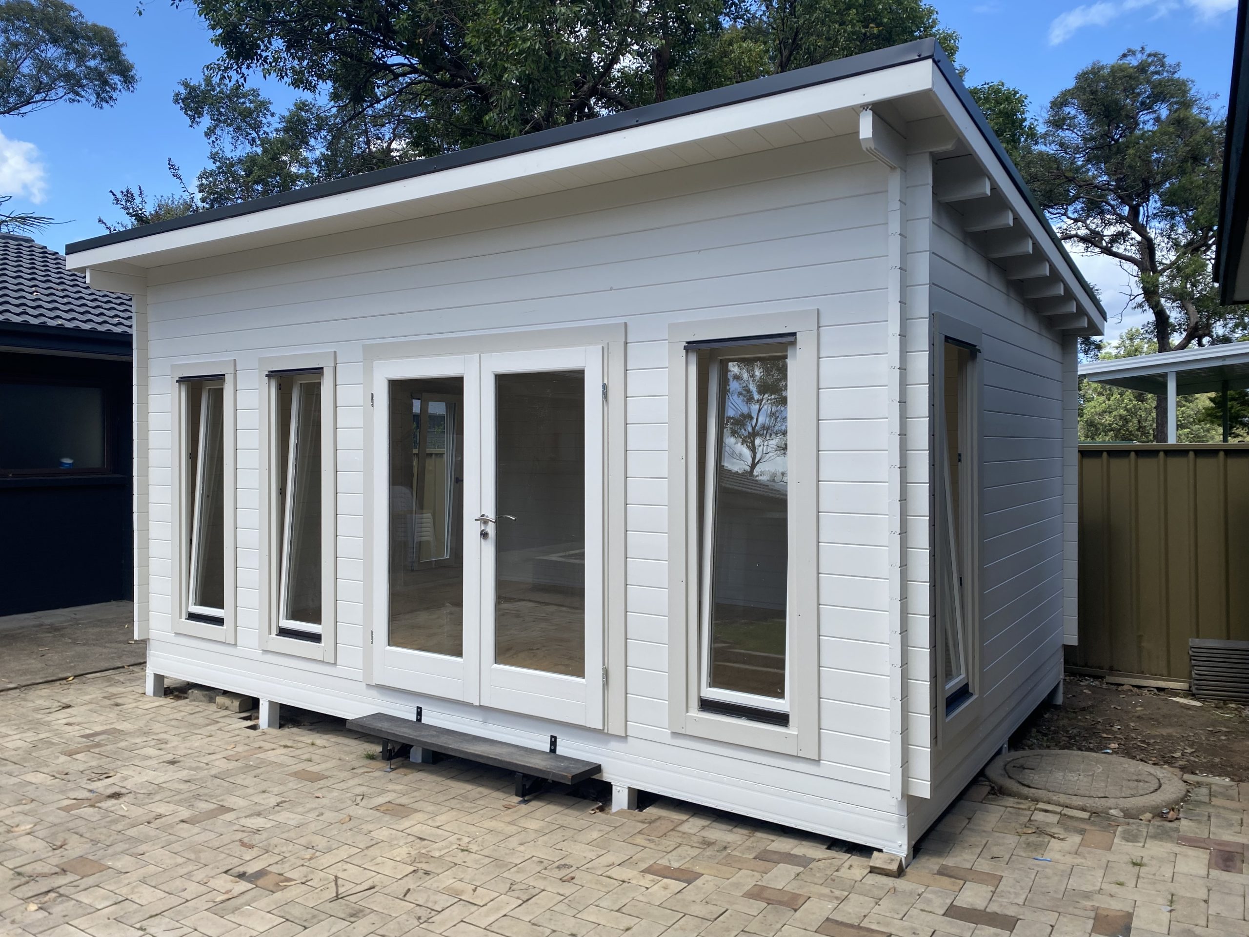 outside of painted alpine display cabin with open tilt and turn windows