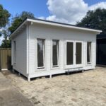 outside of painted alpine display cabin with open tilt and turn windows