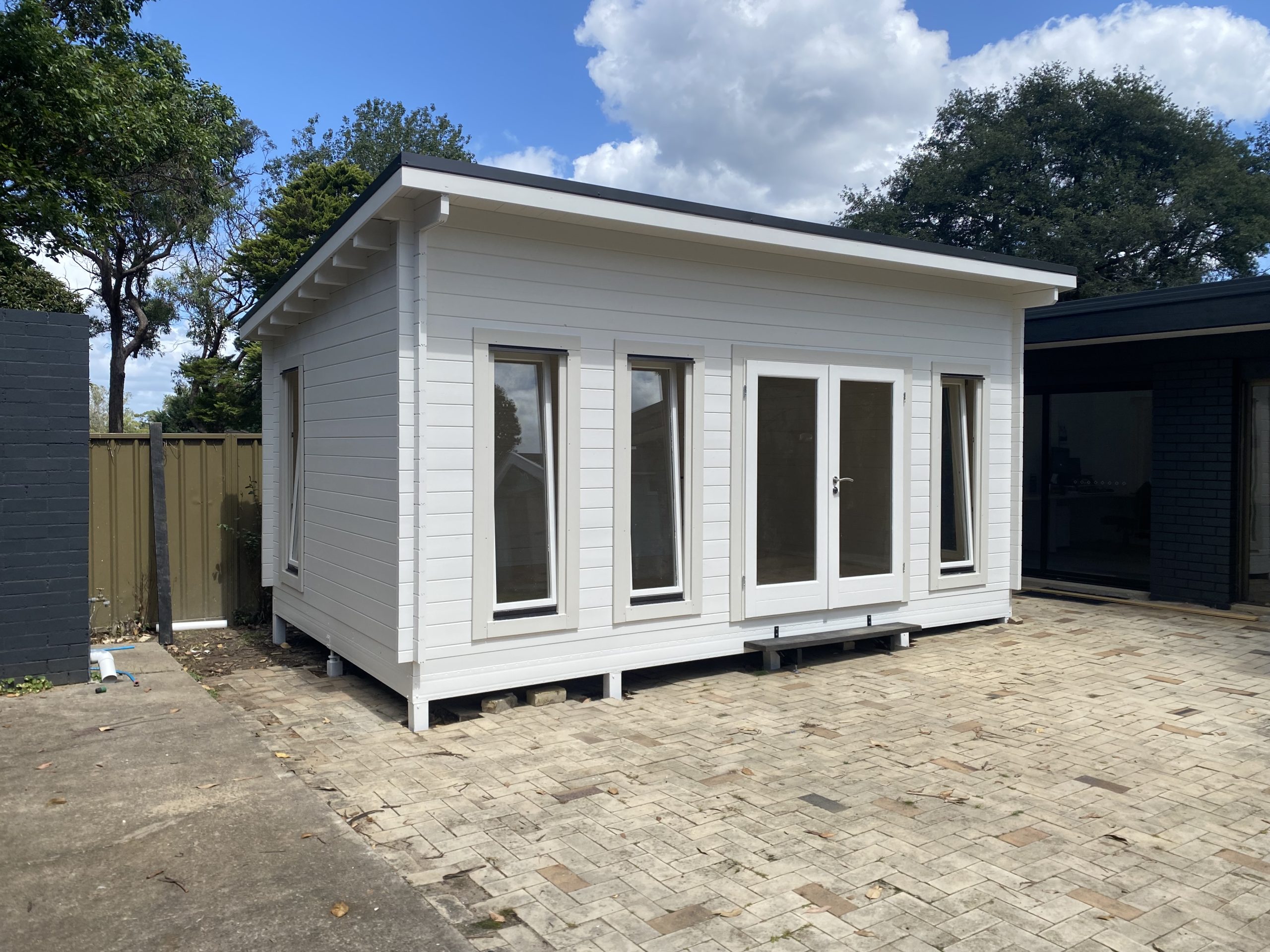 outside of painted alpine display cabin with open tilt and turn windows