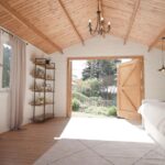inside of tasman display cabin retreat and reading room with lounge and desk with lights on and open barn door