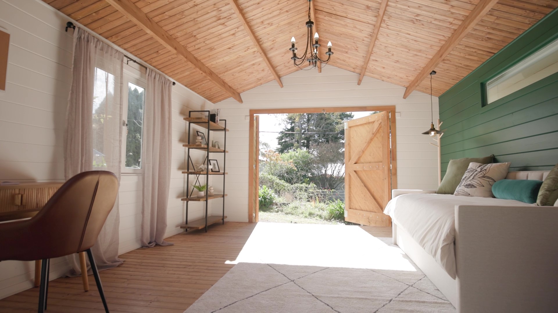 inside of tasman display cabin retreat and reading room with lounge and desk with lights on and open barn door
