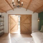 inside of tasman display cabin retreat and reading room with open barn door and lights on