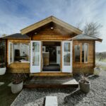 outside of lake cabin as an upholstery studio with windows and doors open