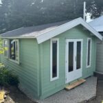 light green painted display tasman cabin with open double windows