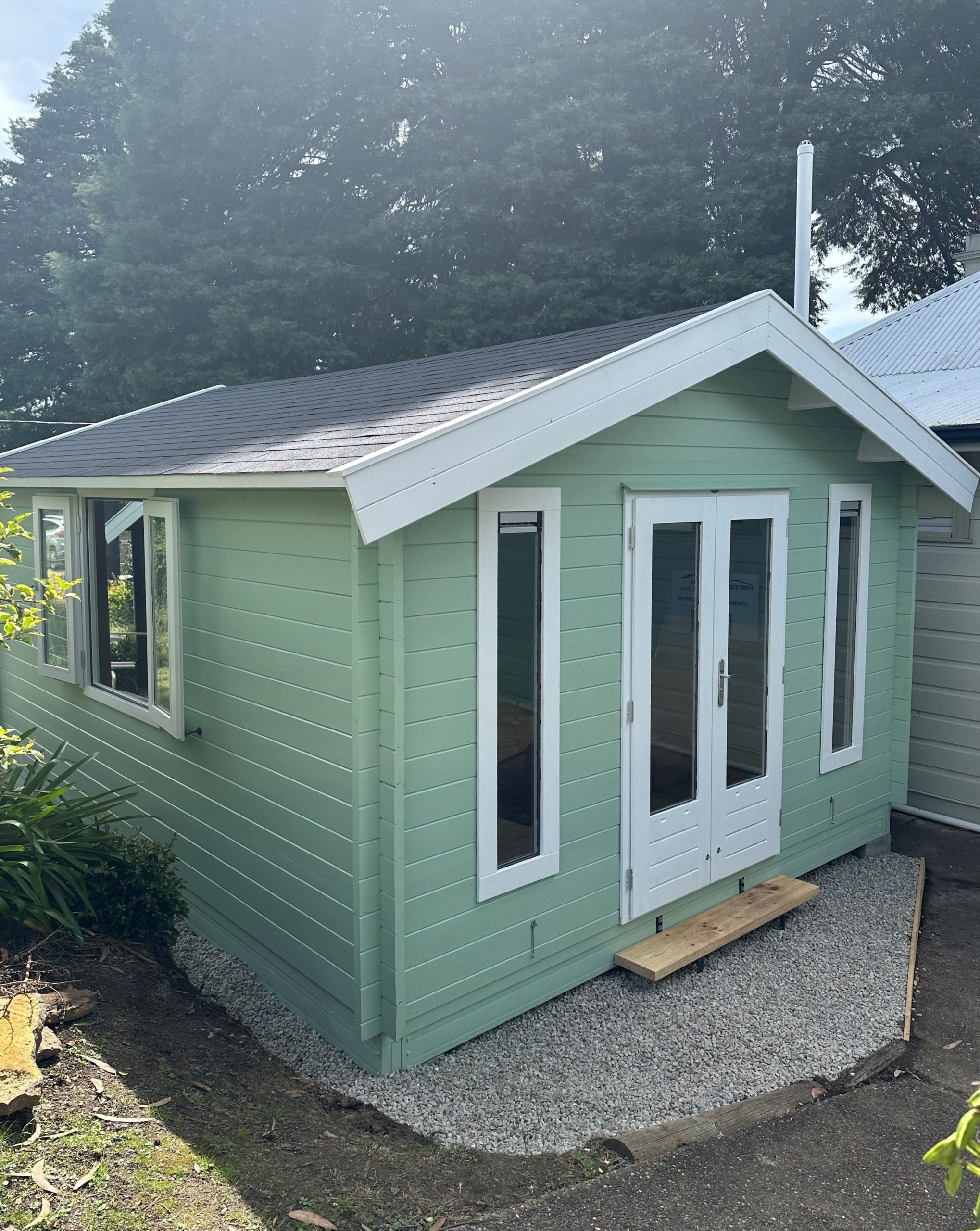 light green painted display tasman cabin with open double windows