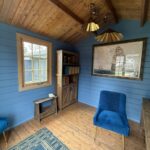 inside of painted star cabin display home office with casement window and brass lights