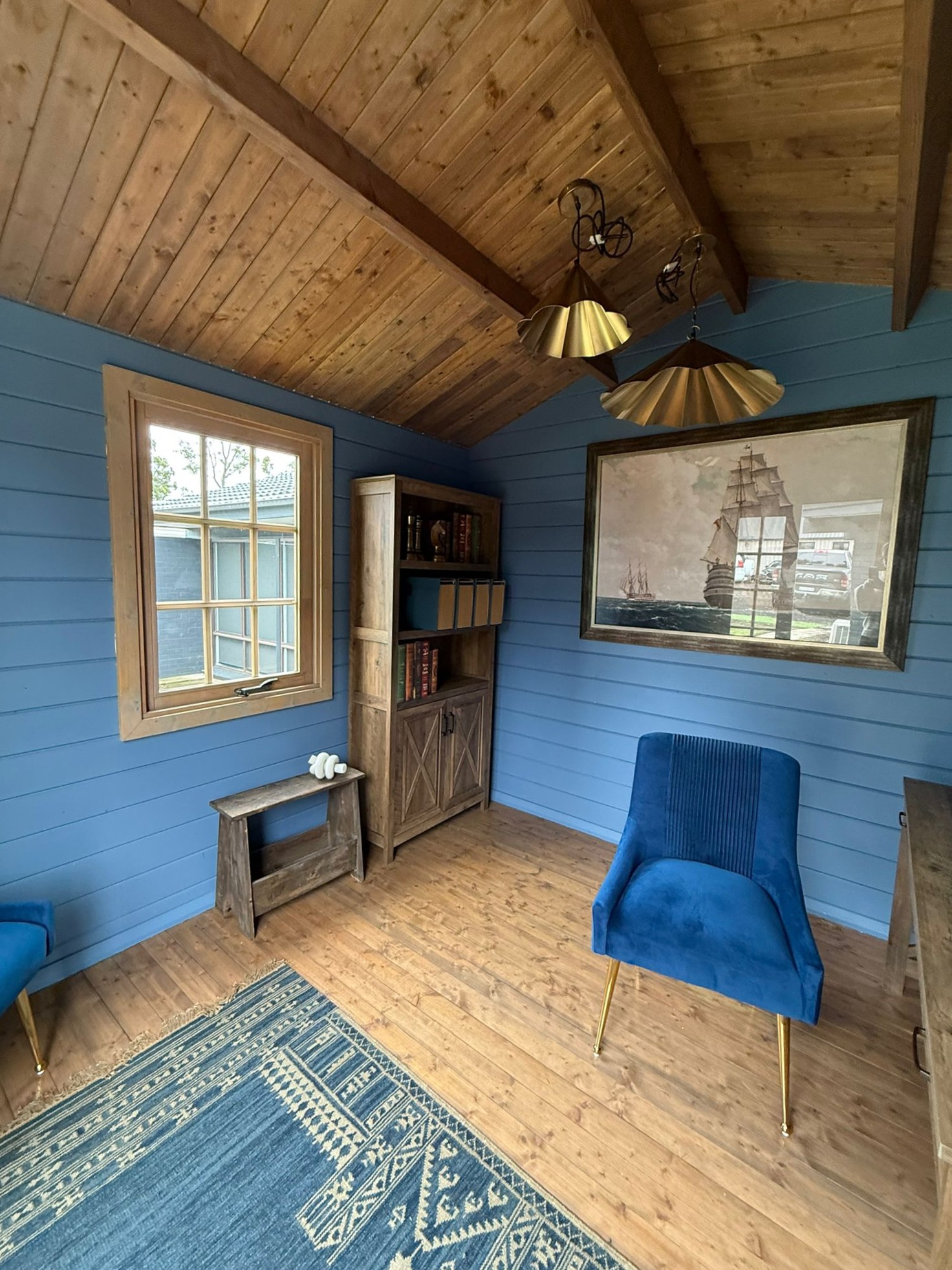 inside of painted star cabin display home office with casement window and brass lights