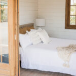looking into white painted star canopy cabin styled as a bedroom