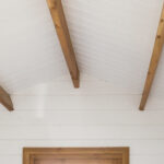white painted roof and unpainted timber beams inside star cabin canopy display