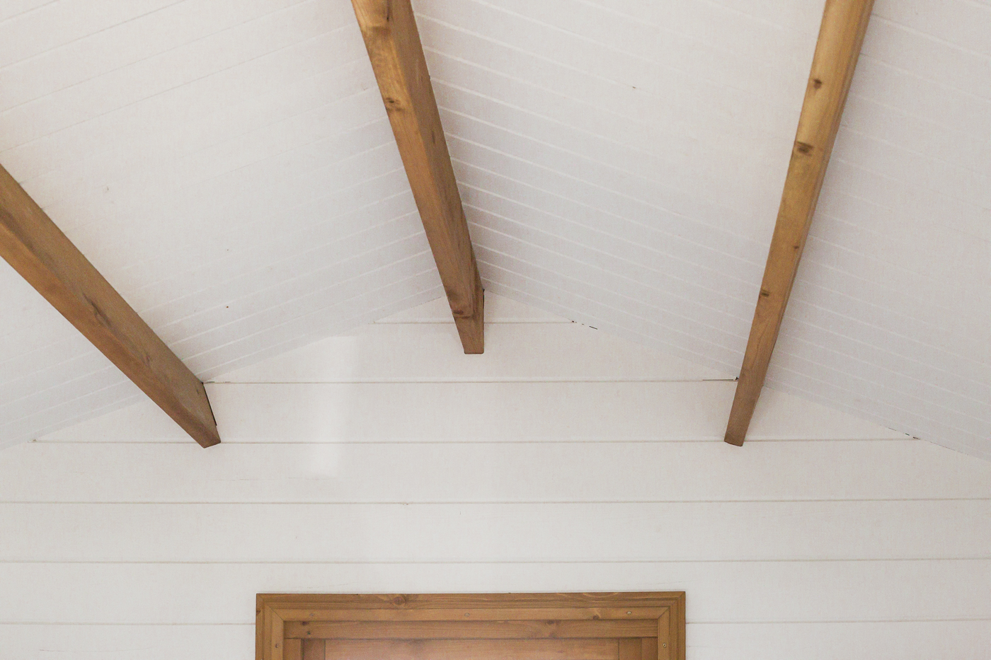 white painted roof and unpainted timber beams inside star cabin canopy display