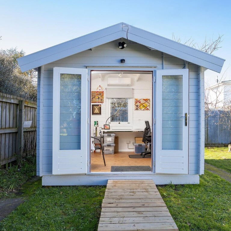 inside of painted star cabin sewing room with open french doors in backyard