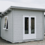 outside of painted star summit display cabin home office with french doors
