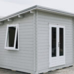 outside of painted star summit display cabin home office with french doors