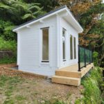 outside of painted tussock cabin home office with small deck
