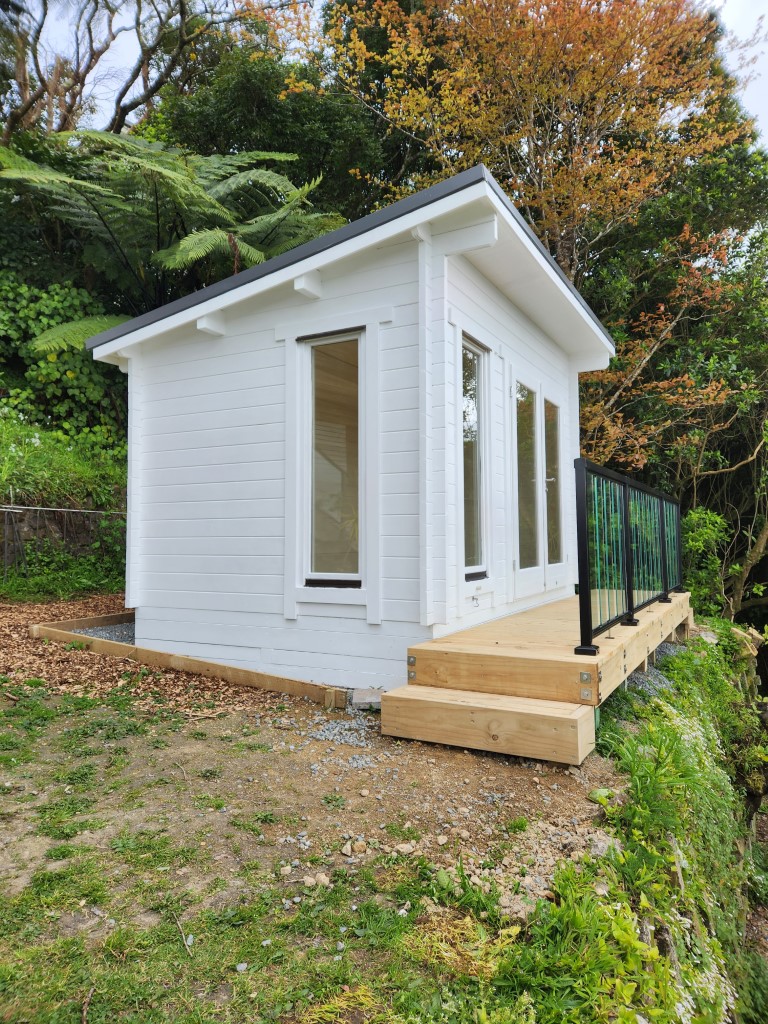 outside of painted tussock cabin home office with small deck