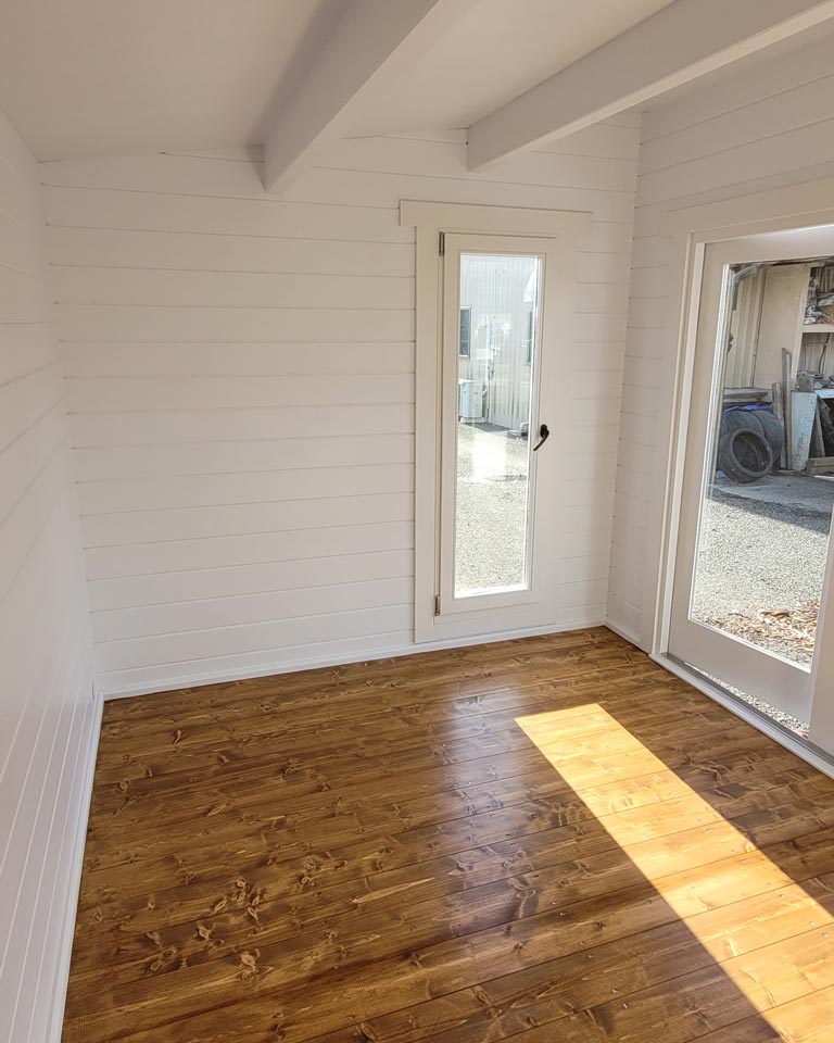 inside of unfurnished tussock display cabin with tilt and turn window and floorboards
