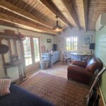 inside woodland cabin used as backyard retreat with pendant light and french doors and casement window