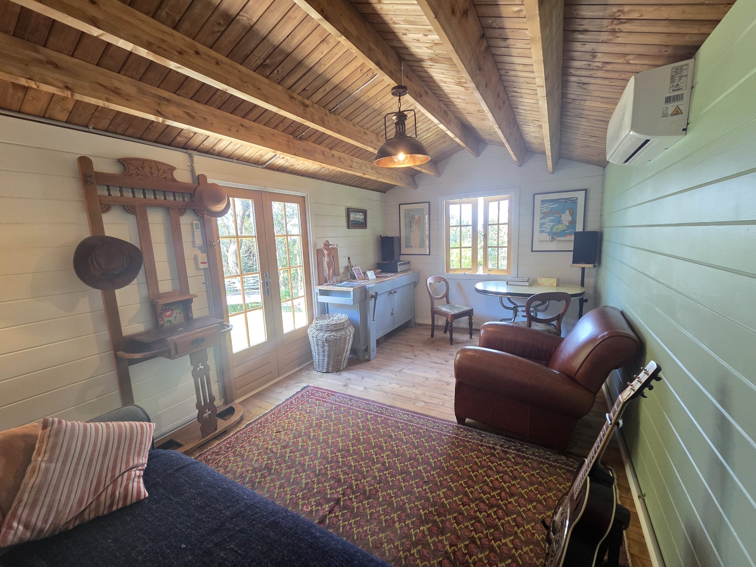 inside woodland cabin used as backyard retreat with pendant light and french doors and casement window