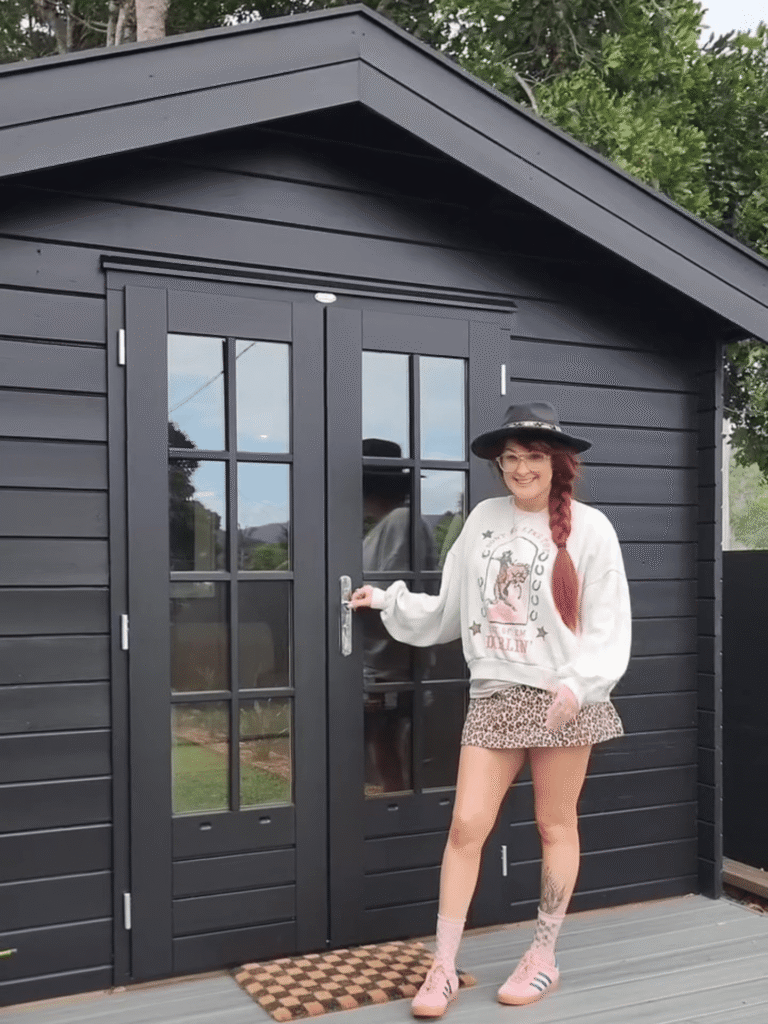 Tam standing proudly in front of her SheShed 